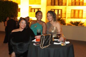 Three women sitting at a table with wine glasses.