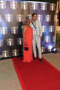 A man and woman posing on the red carpet.