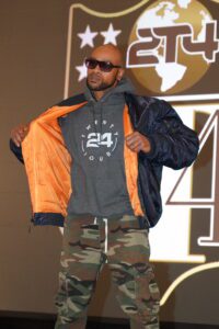 A man in sunglasses and an orange jacket.