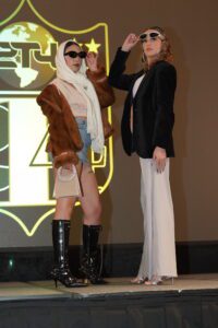 Two women in a fashion show posing for the camera.