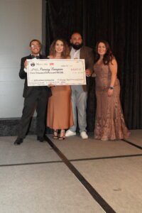 A group of people holding up a giant check.