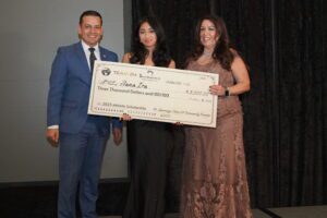 A couple of people holding up a giant check