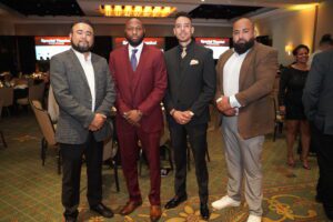 Four men in suits and ties standing next to each other.