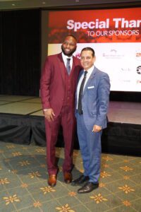 Two men in suits pose for a picture.