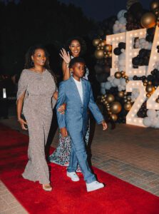 A group of people walking on a red carpet.