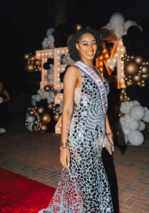 A woman in a leopard print dress standing on the red carpet.