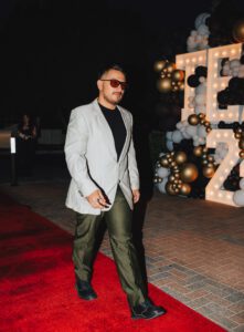 A man in a suit and sunglasses on the red carpet.