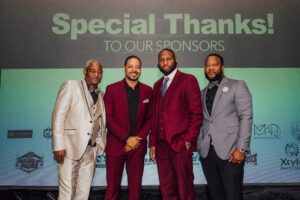 Four men in suits and ties standing next to each other.