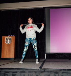 A woman in grey shirt and blue pants holding onto a rope.