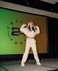 A woman in white outfit doing a pose on stage.