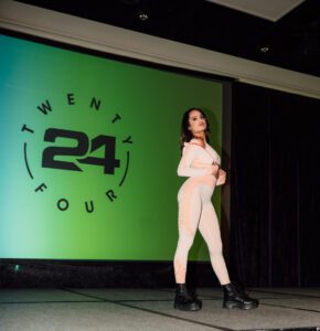 A woman in white shirt and black boots on stage.