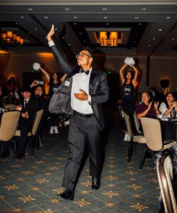 A man in a suit and tie holding up two white paper plates.