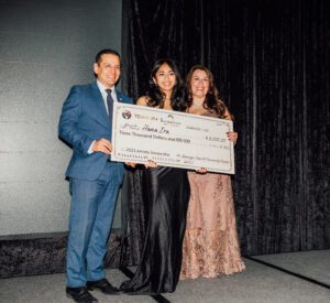 A couple of people holding up a giant check