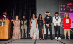 A group of people standing on the stage at a fashion show.