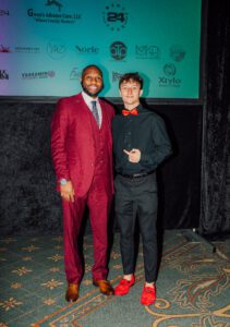 Two men in suits pose for a picture.