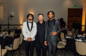 Three men in suits posing for a picture.