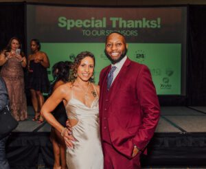 A man and woman posing for the camera at an event.