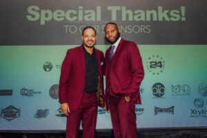 Two men in suits posing for a picture.