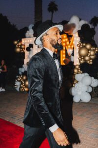 A man in a suit and hat walking down the street.