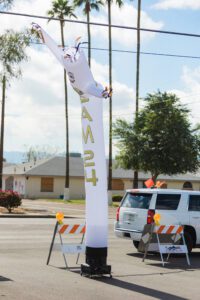 A person is hanging from the air on a white pole.