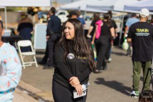 A woman in black shirt holding a white bag.