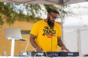 A man in yellow shirt playing a dj.