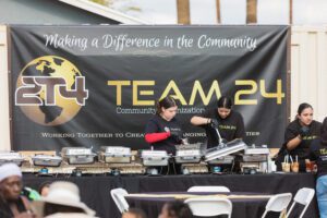 A group of people cooking food on top of pans.