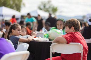 A group of people sitting around tables with food.