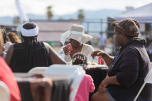 A group of people sitting at tables with food.