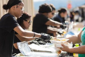 A group of people standing around serving food.