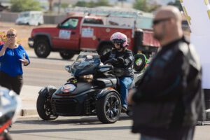 A man riding on the back of a black motorcycle.