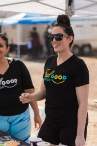 Two women walking down a street wearing black shirts.