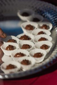 A tray of chocolate covered cookies on top of white paper.