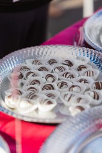 A plate of chocolate covered marshmallows on top of a table.