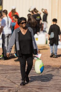 A woman walking down the street holding a bag.