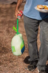 A person holding a bottle of water and spray.