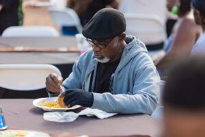 A man eating food at an outdoor table.