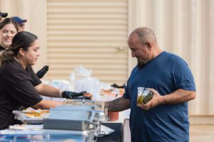 A man is serving food to another person.