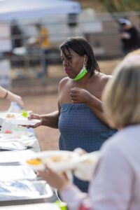 A woman standing at the table with plates of food.