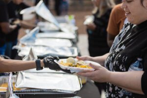 A woman is holding food at the table