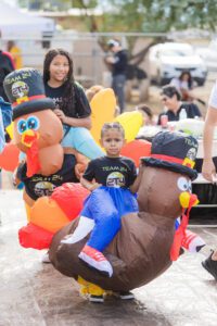 A group of people sitting around with inflated turkeys.