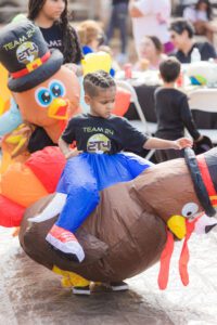 A boy riding on the back of a turkey.