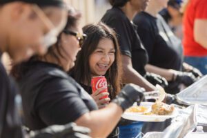 A group of people sitting at a table with food.