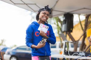 A woman holding onto some tickets and smiling.