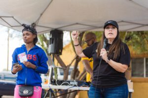 A woman is speaking at an outdoor event.