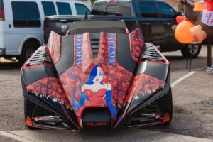 A car with a woman on the hood