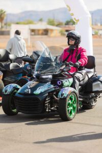 A person on a three wheeled motorcycle.