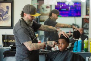 A man is getting his hair cut by another person.