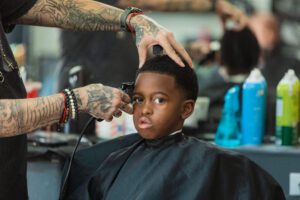 A person getting his hair cut by someone