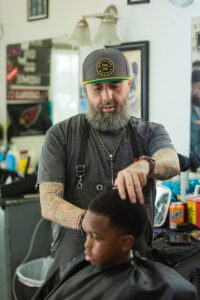 A barber cutting the hair of a young boy.